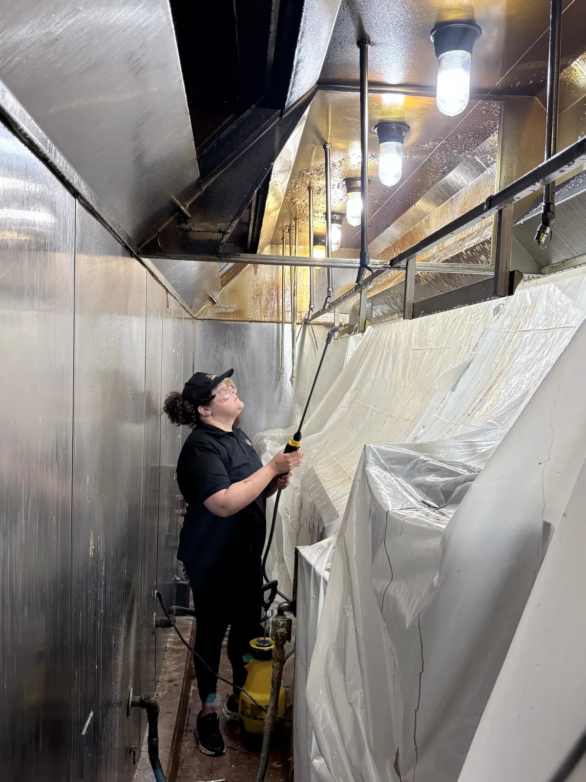 ARC technician performing commercial kitchen hood cleaning